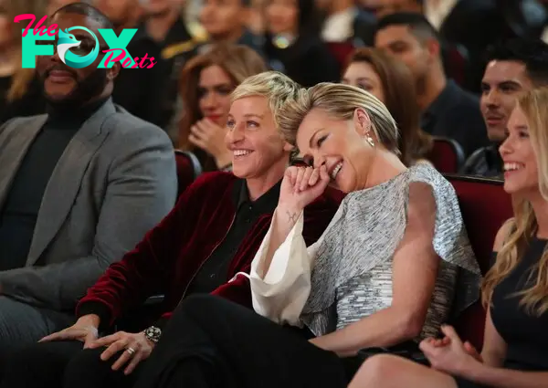 Ellen DeGeneres and Portia De Rossi seated and laughing at the 2017 People's Choice Awards.