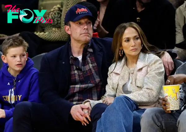 Ben Affleck and his son, Samuel, sitting next to Jennifer Lopez at a basketball game