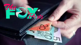 A hand pulling Australian cash out of a wallet