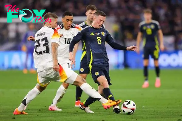 Callum McGregor of Scotland battles for possession with Robert Andrich of Germany  during the UEFA EURO 2024 group stage match between Germany and ...