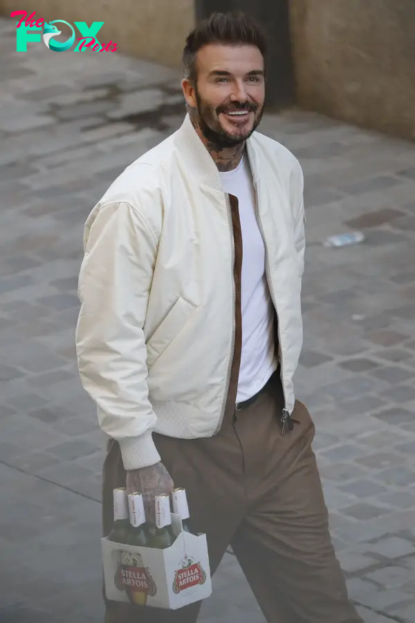 David Beckham flashed a beaming smile as he carried a six-pack of Stella Artois in Barcelona