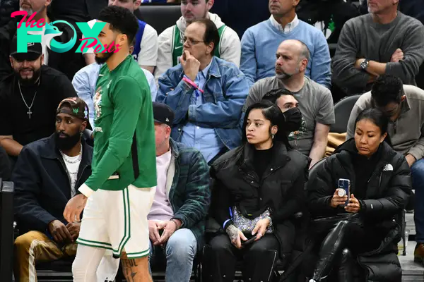 Jayson Tatum playing basketball while Ella Mai watches.