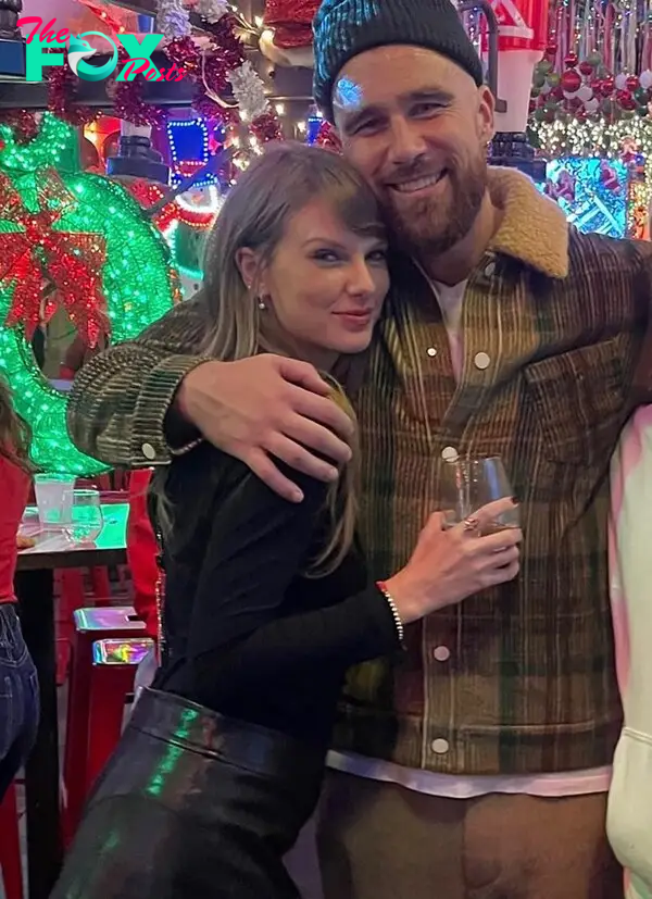 Travis Kelce and Taylor Swift  posing for a photo together. 