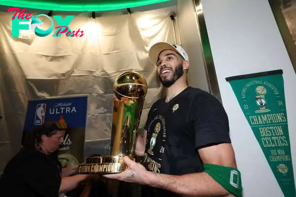 Boston Celtics forward Jayson Tatum (0) holds the Larry O’Brien Championship Trophy