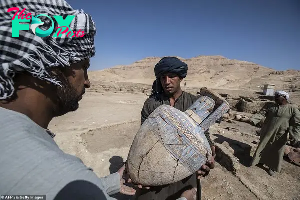 Workers carrying a painted pot at the archaeological site of a 3000 year old city, dubbed The Rise of Aten, dating to the reign of Amenhotep III, uncovered by the Egyptian mission near Luxor