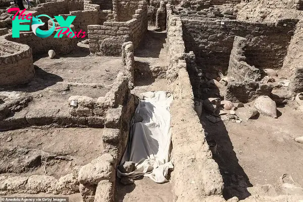 A narrow passageway is seen cutting through the ancient city after workers pulled mud and dirt off the site