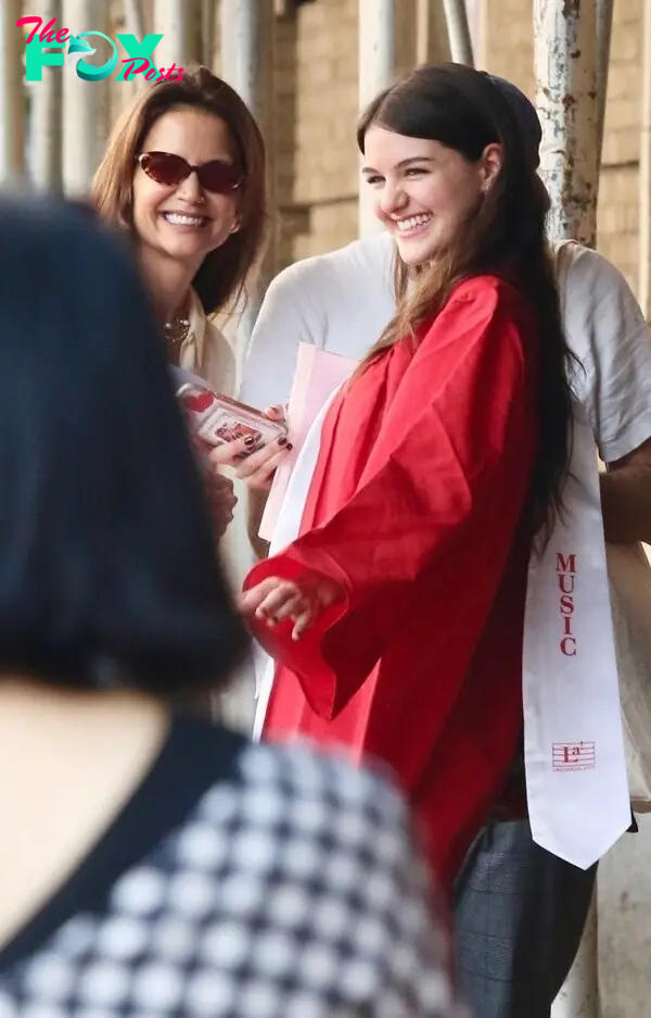 Katie Holmes smiles with her daughter Suri after she graduates high school