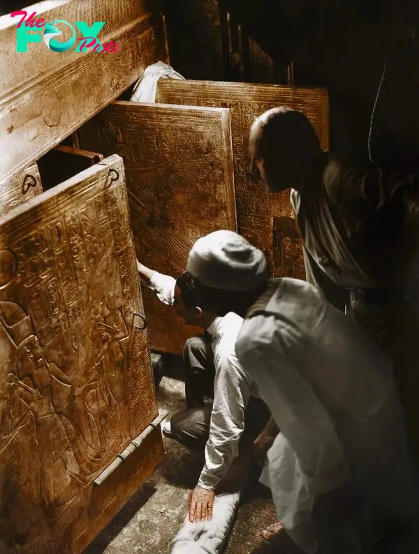 Howard Carter, Arthur Callender and an Egyptian worker open the doors of the innermost shrine and get their first look at Tutankhamun's sarcophagus, 4th January 1924. Image courtesy of Griffith Institute, University of Oxford, colourised by Dynamichrome