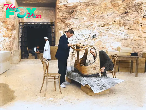 Arthur Mace and Alfred Lucas work on a golden chariot from Tutankhamun's tomb outside the "laboratory" in the tomb of Sethos II, December 1923. Image courtesy of Griffith Institute, University of Oxford, colourised by Dynamichrome