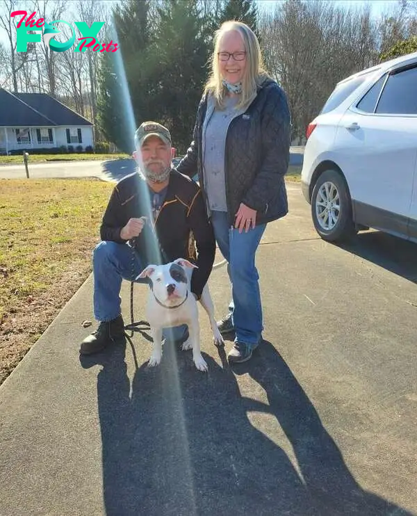 Dog poses with her new family.