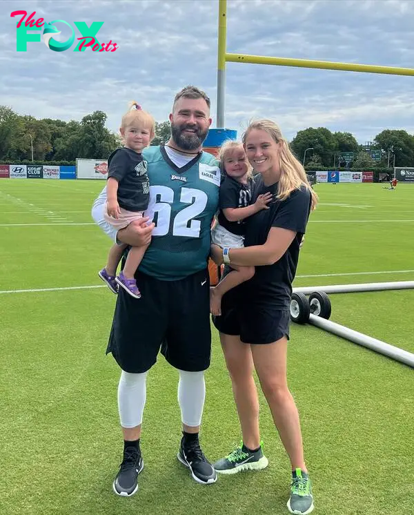 jason and kylie kelce on a football field with two of their daughters