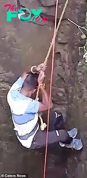 Govind Solanki, a volunteer with Wild and Street Animal Rescue Society in India, climbs down to save the snake