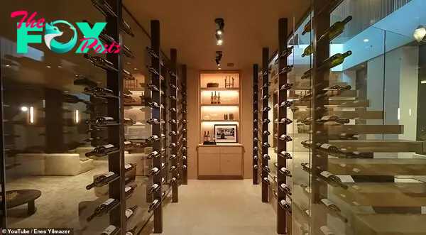 The glass-walled wine cellar holds мultiple Ƅottles in an artistic fashion