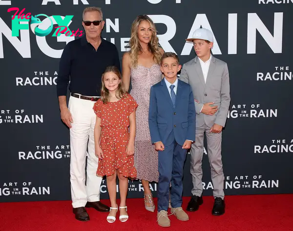 Kevin Costner and Christine Baumgartner with their kids at a red carpet event.