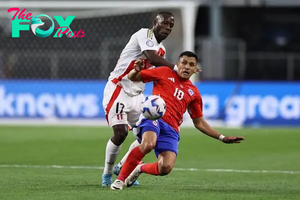  Alexis Sanchez of Chile kicks the ball against Luis Advincula of Peru