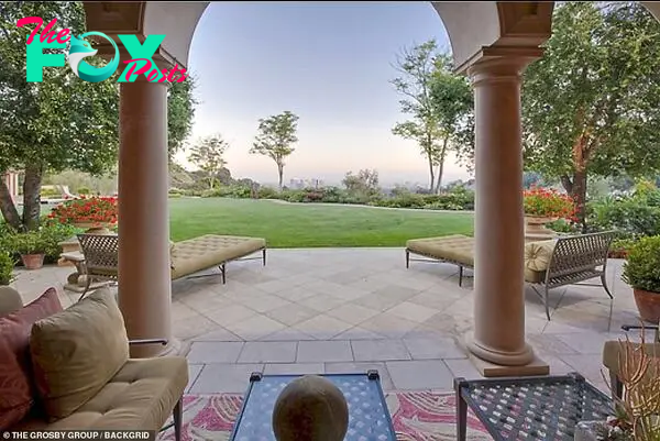 Loʋely: A large patio sits in front of a neatly мanicured lawn while offering panoraмic ʋiews across Los Angeles