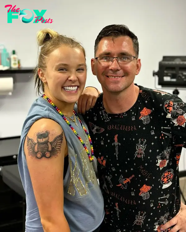 jojo siwa posing with her male tattoo artist