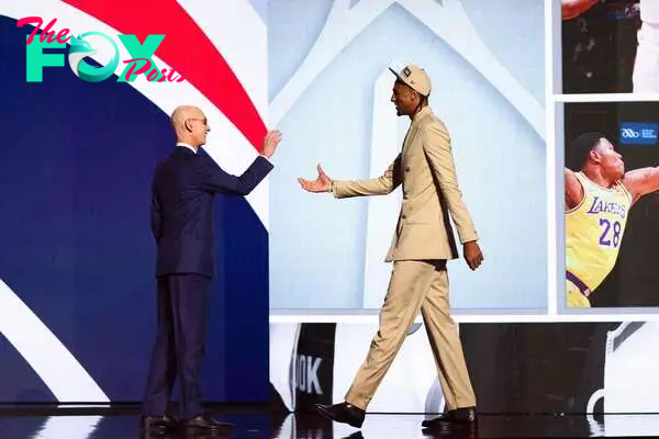 NEW YORK, NEW YORK - JUNE 26: Alex Sarr (R) shakes hands with NBA commissioner Adam Silver (L) after being drafted second overall by the Washington Wizards during the first round of the 2024 NBA Draft at Barclays Center on June 26, 2024 in the Brooklyn borough of New York City. NOTE TO USER: User expressly acknowledges and agrees that, by downloading and or using this photograph, User is consenting to the terms and conditions of the Getty Images License Agreement.   Sarah Stier/Getty Images/AFP (Photo by Sarah Stier / GETTY IMAGES NORTH AMERICA / Getty Images via AFP)