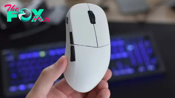 The Endgame Gear XM2WE gaming mouse being held up in front of a keyboard.