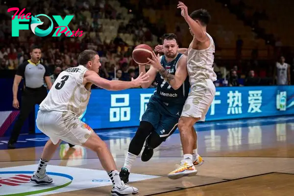 Slovenia�s Luka Doncic (C) fights for the ball with New Zealand�s Finn Delany (L) during the 2024 FIBA Olympic Qualifying Tournament basketball match between New Zealand and Slovenia at the Peace and Friendship Stadium in Athens on July 4, 2024. (Photo by Aris MESSINIS / AFP)