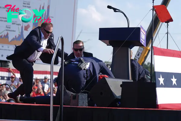 U.S. Secret Service agents converge to cover Republican presidential candidate former President Donald Trump at a campaign rally, July 13, 2024, in Butler, Pa.