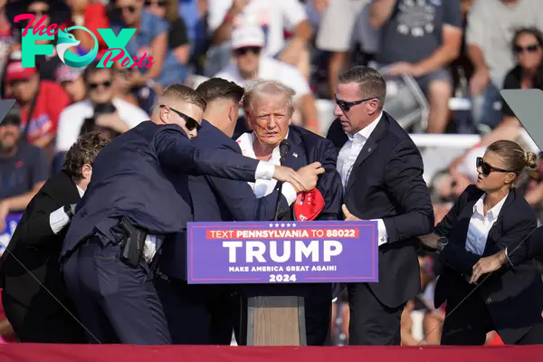 Republican presidential candidate former President Donald Trump is helped off the stage at a campaign event in Butler, Pa., on July 13, 2024.