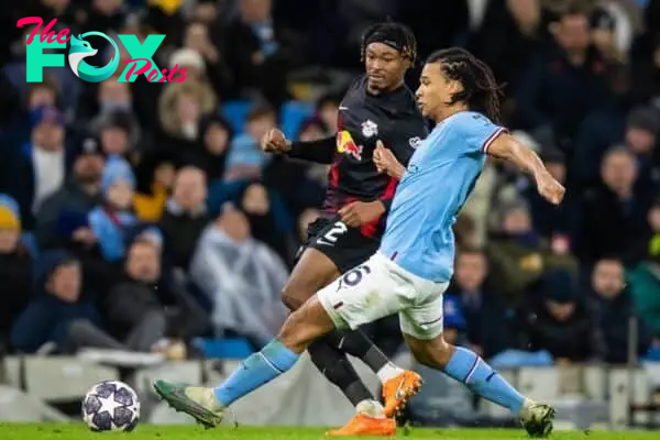 MANCHESTER, ENGLAND - Tuesday, March 14, 2023: RB Leipzig's Mohamed Simakan (L) is challenged by Manchester City's Nathan Aké during the UEFA Champions League Round of 16 2nd Leg match between Manchester City FC and RB Leipzig at the City of Manchester Stadium. Man City won 7-0, 8-1 on aggregate. (Pic by Jessica Hornby/Propaganda)