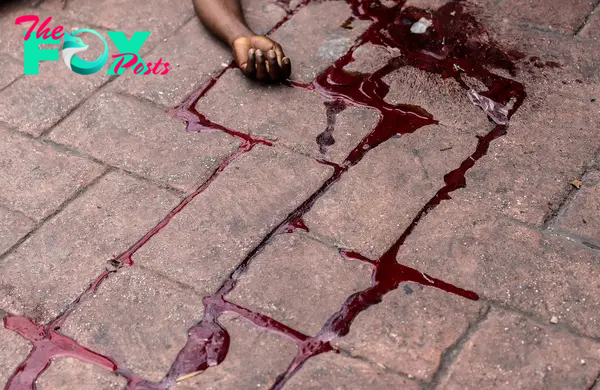 The body of a man shot dead lies in a pool of blood in the Petion-Ville neighborhood of Port-au-Prince on May 3.