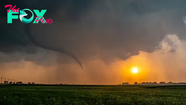 Right at sunset, a brief rope tornado spins in the fields east of Tonkawa, Okla., on May 12, 2023