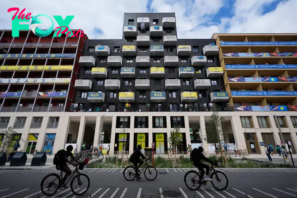 People ride bicycles in front of the Team Australia residence in the Olympic Village, on July 23, 2024.