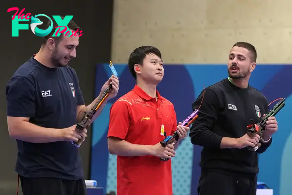 PARIS 2024 OLYMPICS  - Shooting - 10m Air Pistol Men's Final - Chateauroux Shooting Centre, Dols, France - July 28, 2024. (L-R) Federico Nilo Maldini of Italy  , Yu Xie (C) of China, and Paolo Monna of Italy pose with their pistols after finishing second, first and third. REUTERS/Amr Alfiky