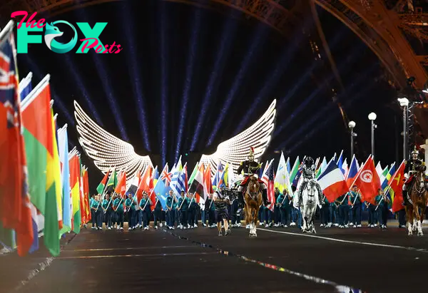 Flag-bearers enter the Trocadero during the opening ceremony.