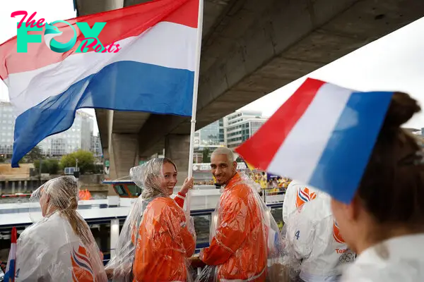 Netherlands' flag bearer Lois Abbingh and Netherlands' flag bearer Worthy Donovan Rafael de Jong sail aboard the boat of the Netherland's delegation along the river Seine during the opening ceremony.