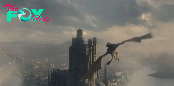 Syrax, a giant yellow dragon, flies through the skies of King’s Landing toward the Red Keep in House of the Dragon