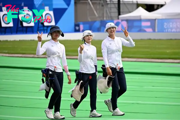 (FromR) South Korea's Lim Si-hyeon, South Korea's Jeon Hun-young and South Korea's Nam Su-hyeon return after collecting their arrows during the Women's Individual Preliminary Round during the Paris 2024 Olympic Games at the Esplanade des Invalides in Paris on July 25, 2024. (Photo by Punit PARANJPE / AFP)