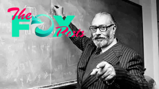 Black and white photo of Abdus Salam teaching at a blackboard.