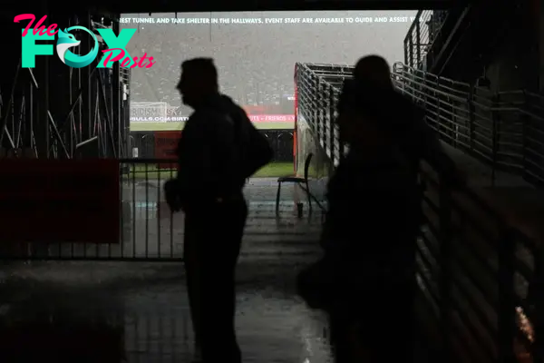 State Police officers shelter from rain as the match has been suspended during the pre-season club friendly football match between Real Madrid and FC Barcelona at MetLife Stadium, in East Rutherford, New Jersey on August 3, 2024. (Photo by Charly TRIBALLEAU / AFP)