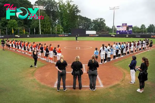 GREENVILLE, NORTH CAROLINA - AUGUST 07: Team Kilfoil and Team McQuillin starters stand for the national anthem with Little League World Series players during an Athletes Unlimited Pro game at Max R. Joyner Family Stadium on August 07, 2024 in Greenville, North Carolina.   Grant Halverson/Getty Images/AFP (Photo by GRANT HALVERSON / GETTY IMAGES NORTH AMERICA / Getty Images via AFP)