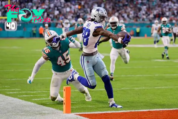 MIAMI GARDENS, FLORIDA - DECEMBER 24: CeeDee Lamb #88 of the Dallas Cowboys scores a touchdown while defended by Duke Riley #45 of the Miami Dolphins during the first quarter at Hard Rock Stadium on December 24, 2023 in Miami Gardens, Florida.   Stacy Revere/Getty Images/AFP (Photo by Stacy Revere / GETTY IMAGES NORTH AMERICA / Getty Images via AFP)