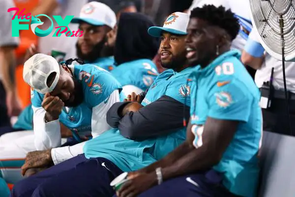 MIAMI GARDENS, FLORIDA - AUGUST 17: Odell Beckham Jr. #3, Tua Tagovailoa #1 and Tyreek Hill #10 of the Miami Dolphins react on the bench against the Washington Commanders during the fourth quarter of a preseason game at Hard Rock Stadium on August 17, 2024 in Miami Gardens, Florida.   Megan Briggs/Getty Images/AFP (Photo by Megan Briggs / GETTY IMAGES NORTH AMERICA / Getty Images via AFP)