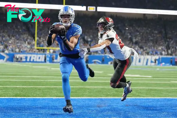 DETROIT, MICHIGAN - JANUARY 21: Amon-Ra St. Brown #14 of the Detroit Lions catches a pass for a touchdown in front of Zyon McCollum #27 of the Tampa Bay Buccaneers during the fourth quarter of the NFC Divisional Playoff game at Ford Field on January 21, 2024 in Detroit, Michigan.   Nic Antaya/Getty Images/AFP (Photo by Nic Antaya / GETTY IMAGES NORTH AMERICA / Getty Images via AFP)