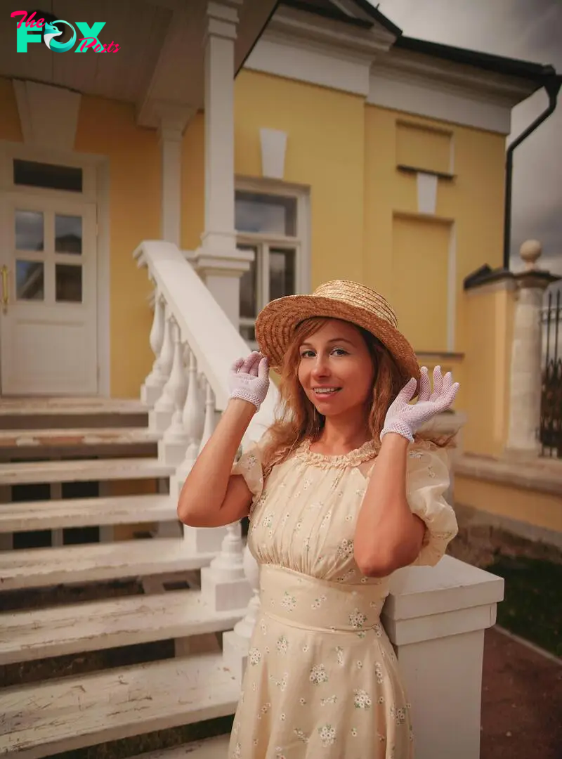 A woman in gardening get-up posing on the front porch of a home | Source: Pexels