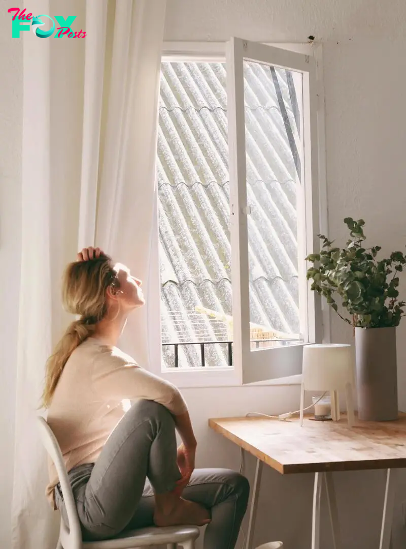 A woman looks thoughtfully out of a window | Source: Pexels