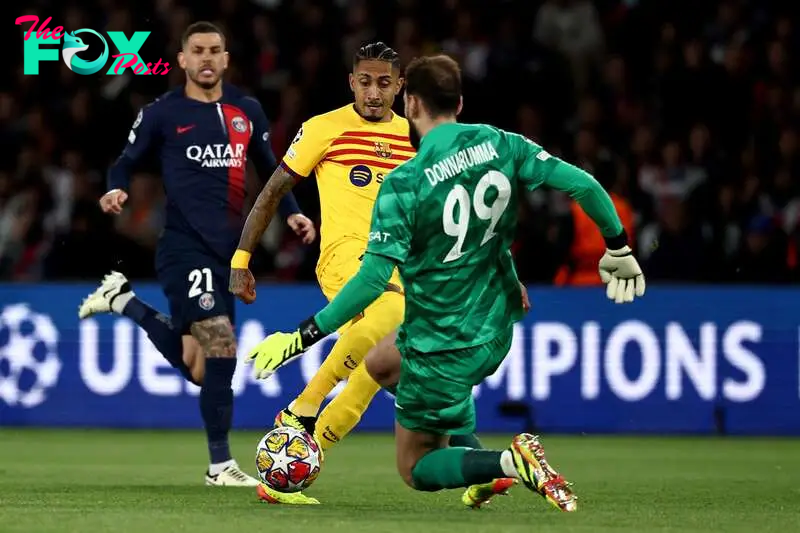 Barcelona's Brazilian forward #11 Raphinha (C) and Paris Saint-Germain's Italian goalkeeper #99 Gianluigi Donnarumma 