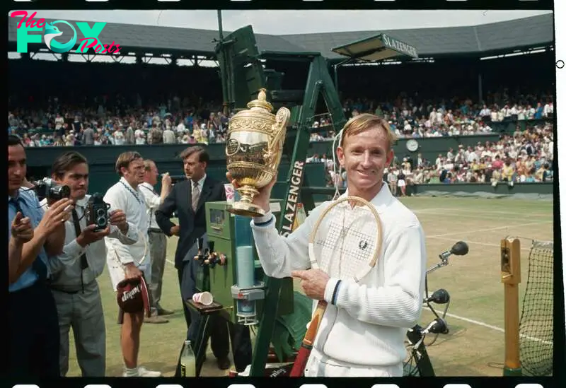 Rod Laver flashes a winning smile as he holds the loving cup high after defeating fellow Australian Tony Roche 6-3, 6-4, 6-2