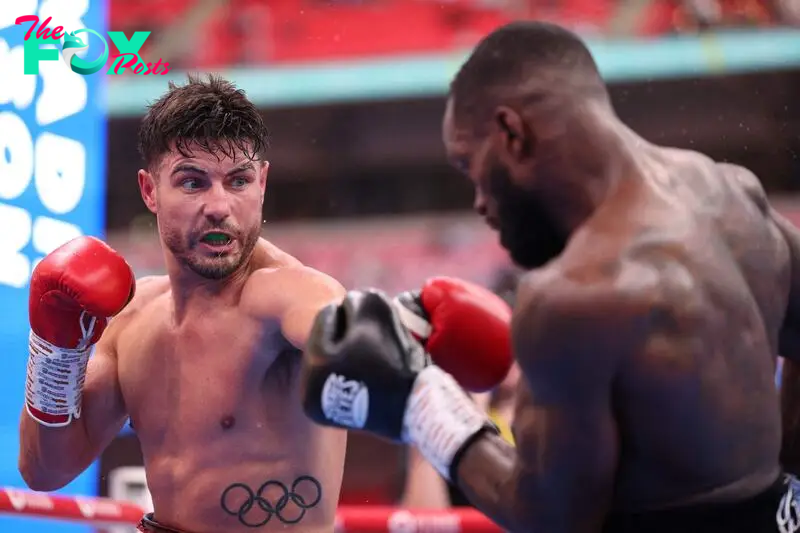 Josh Kelly (L) throws a punch during his win over Ishmael Davis in their middleweight boxing match at Wembley Stadium