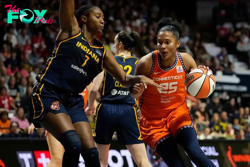 Alyssa Thomas #25 of the Connecticut Sun drives to the rim against Aliyah Boston #7 of the Indiana Fever 