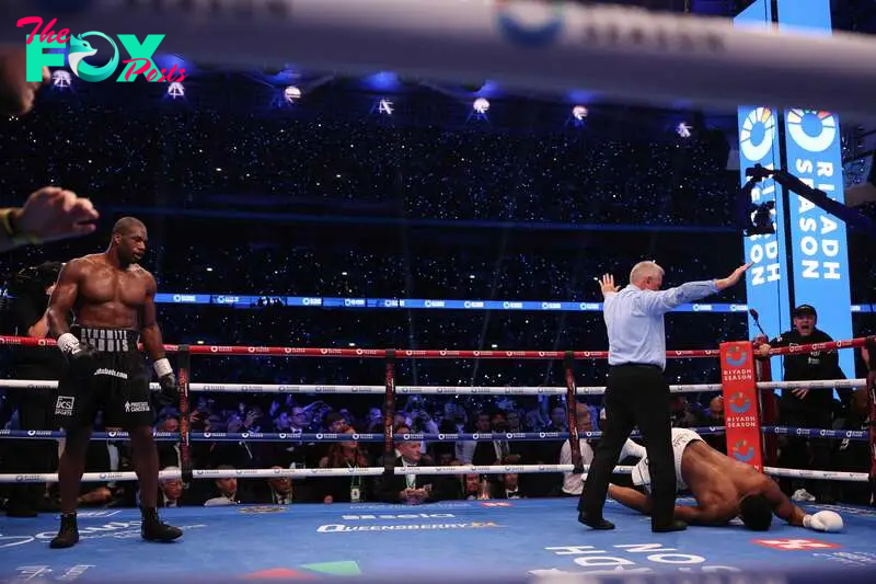 Britain's Anthony Joshua is knocked to the ground by Britain's Daniel Dubois during their heavyweight boxing match for the IBF world title at Wembley Stadium in London on September 21, 2024.  (Photo by Adrian Dennis / AFP)