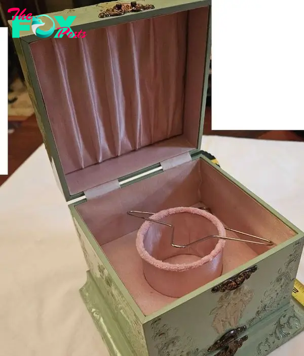 Wooden box painted green with hints of pink and gold.