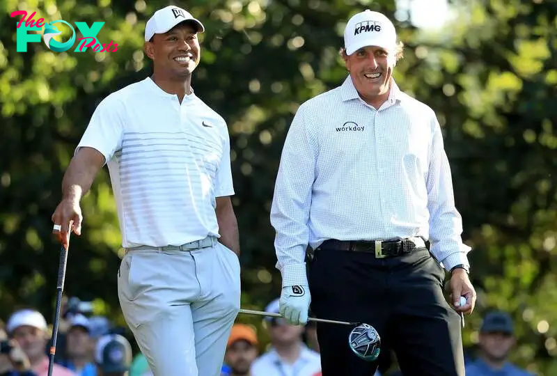 (FILES) In this file photo taken on April 3, 2018, Tiger Woods and Phil Mickelson, of the United States, talk on the 11th hole during a practice round prior to the start of the 2018 Masters Tournament at Augusta National Golf Club in Augusta, Georgia. - Former world number one Tiger Woods and defending champion Phil Mickelson were both named in the field for next week's PGA Championship on Monday. (Photo by Andrew Redington / GETTY IMAGES NORTH AMERICA / AFP)